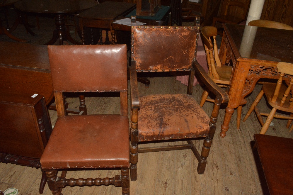 A set of eight Oak Cromwellian style leather covered dining chairs (two carvers)