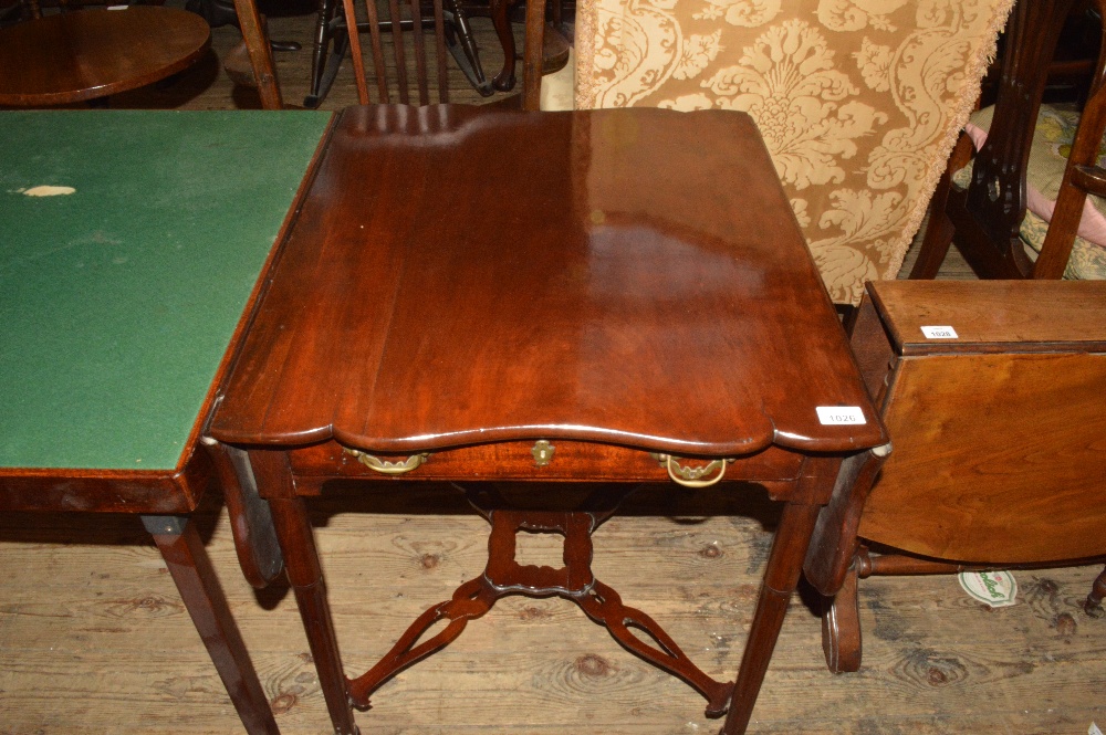 A shaped Mahogany flap leaf table with fluted legs and stretchers