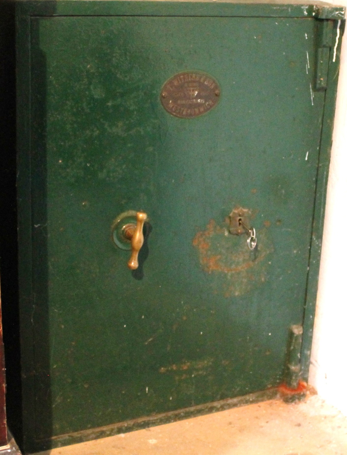 An A T. Withers & Son floor standing metal safe, with key.