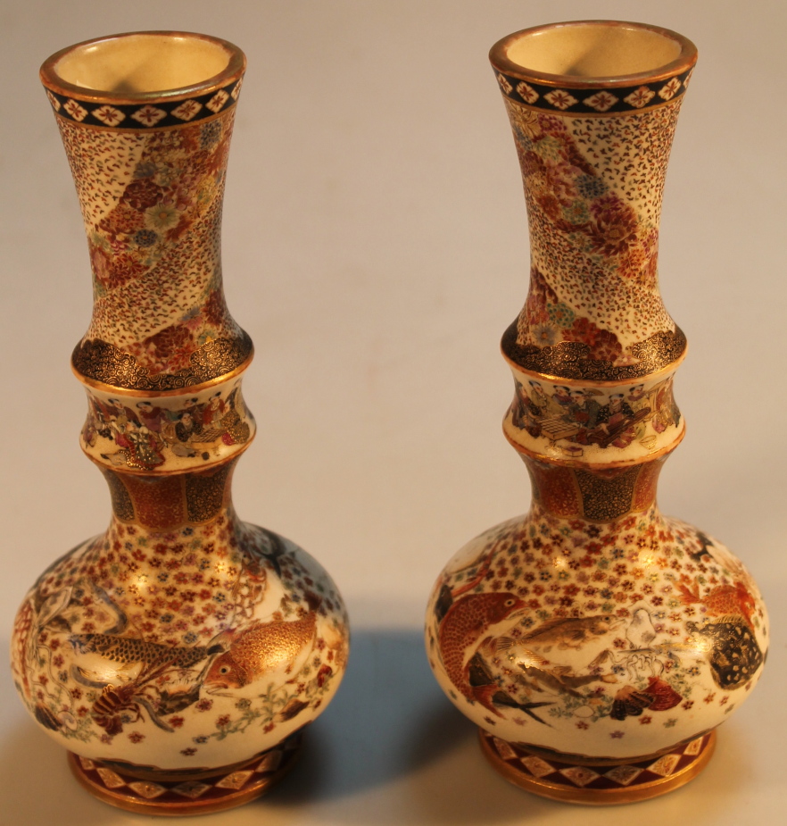 A pair of Japanese satsuma vases, with inverted cylindrical stems and bulbous bodies, decorated with