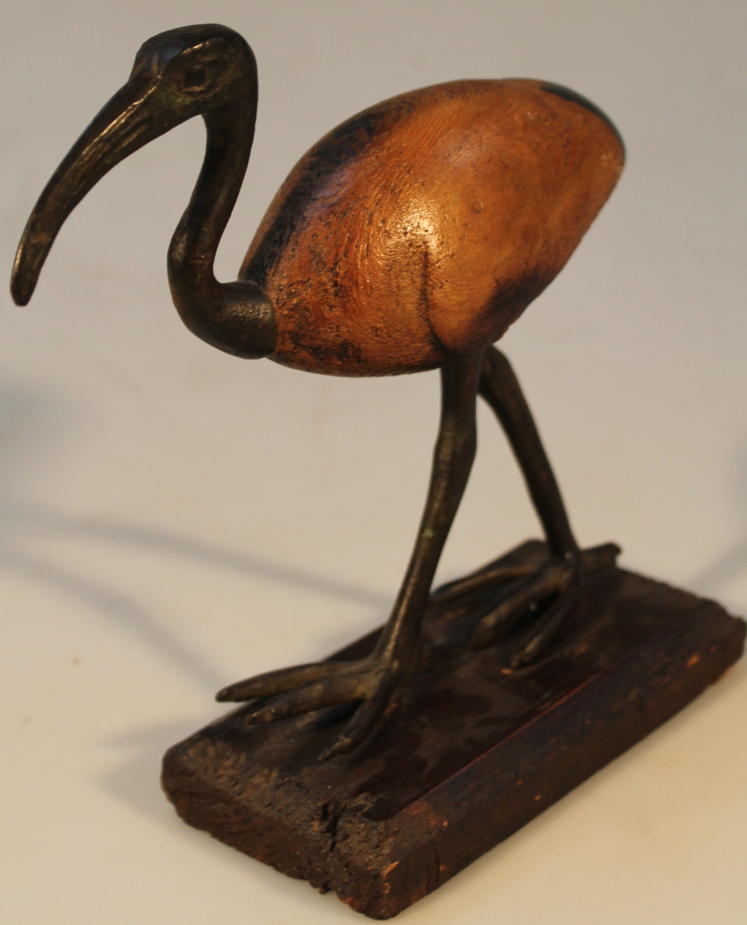 An early 20thC hardwood and metal figure of an ibis, in standing pose on a rectangular wooden