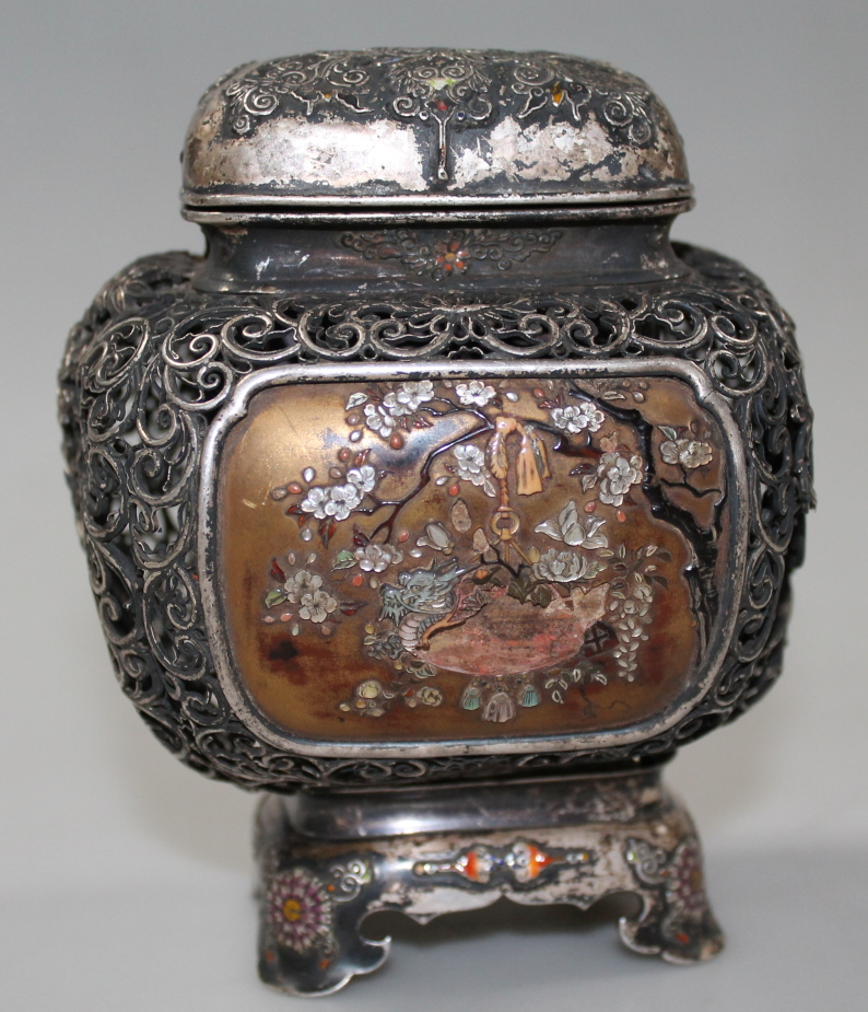 A 19thC white metal tea caddy, the shaped rectangular lid part enamelled in colours and revealing