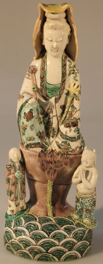 A late 18thC Chinese export figure of Quan Yin, in famille vert colours dressed in robes aside