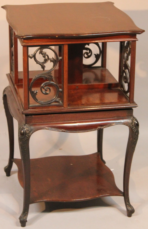An Edwardian mahogany revolving bookcase, by James Shoolbred, the shaped square top raised above a