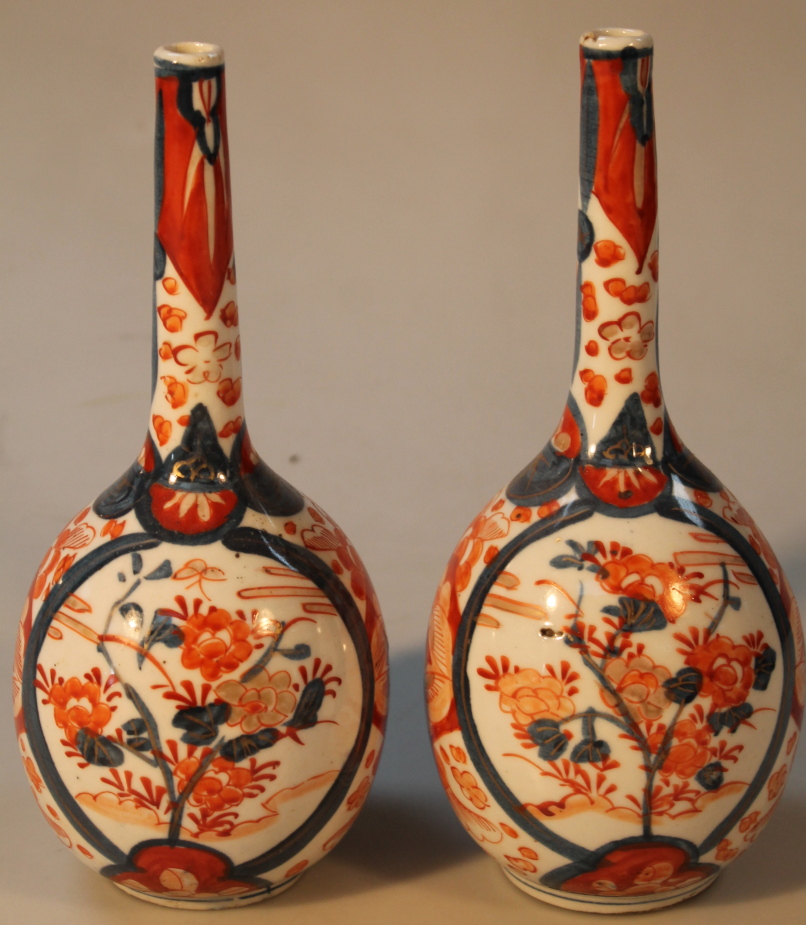 A pair of 19thC Japanese Imari vases, each of bulbous form with slender necks decorated with flowers