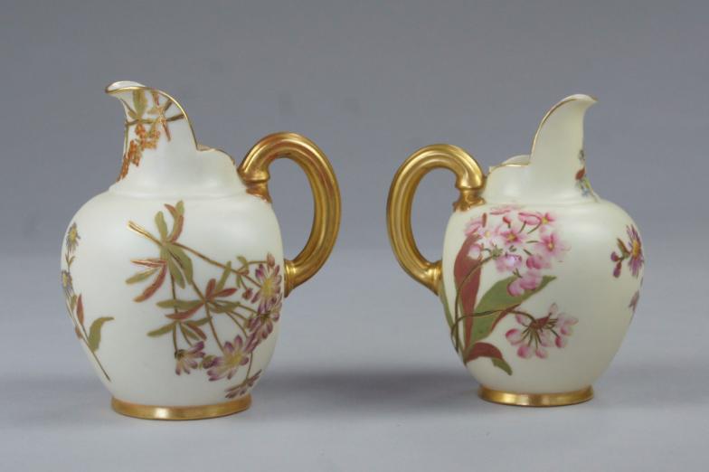 Two Royal Worcester graduated jugs, painted with flowers and with gilt outlines and borders,