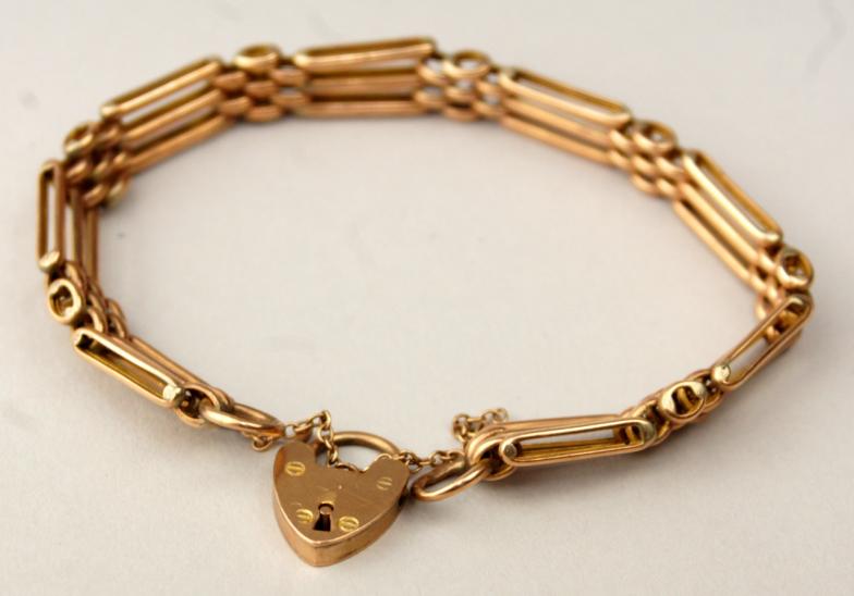 An early 20thC gate link bracelet, with padlock clasp, rose colour metal marked 9ct, 13.3g all in.