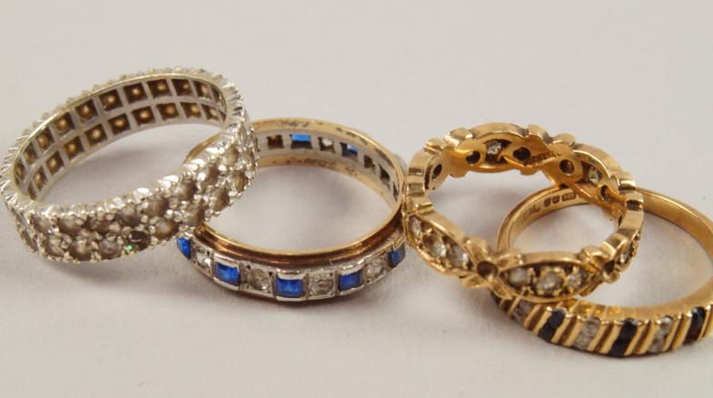 Four dress rings, one 9ct half hoop eternity ring set with blue and white stones (one missing),one