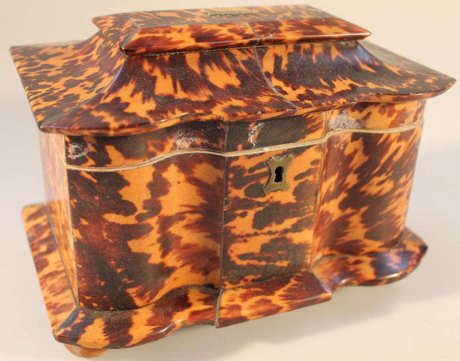 A Regency tortoiseshell and ivory tea caddy of shaped form, with two internal compartments with