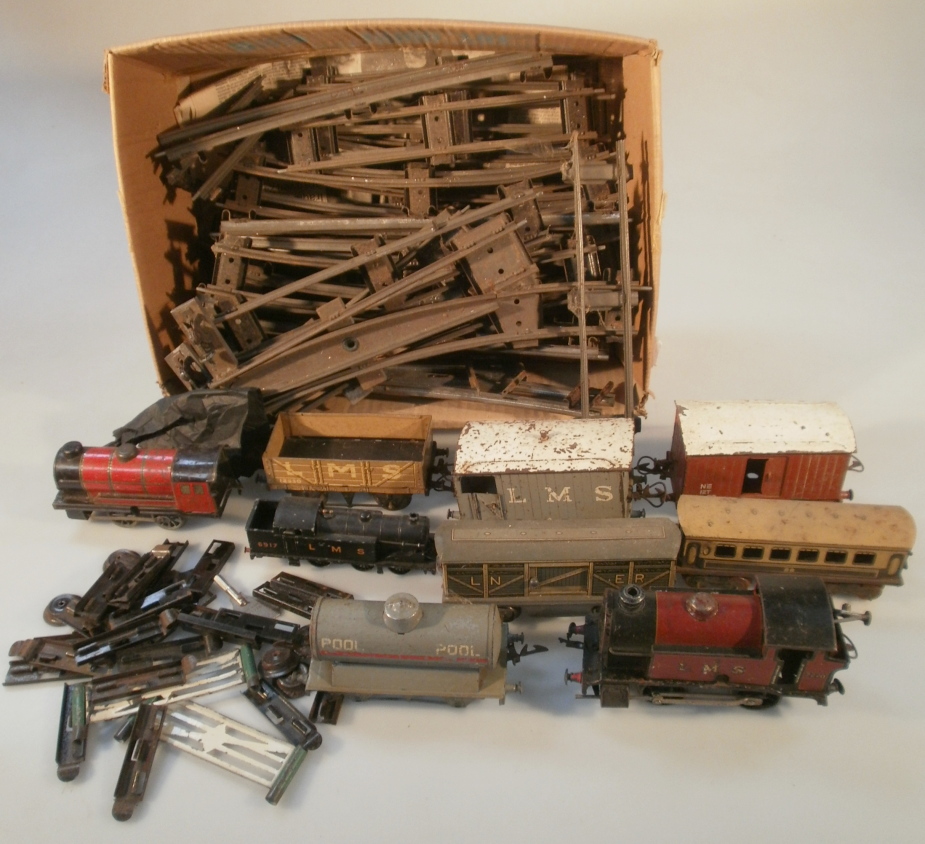 A quantity of Hornby and other 0 gauge tinplate clockwork railway locomotives, wagons and track.