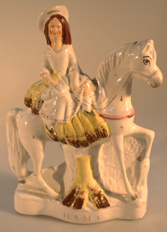 A 19thC Staffordshire pottery equestrian figure group of a woman titled `Home`, 28cm high.