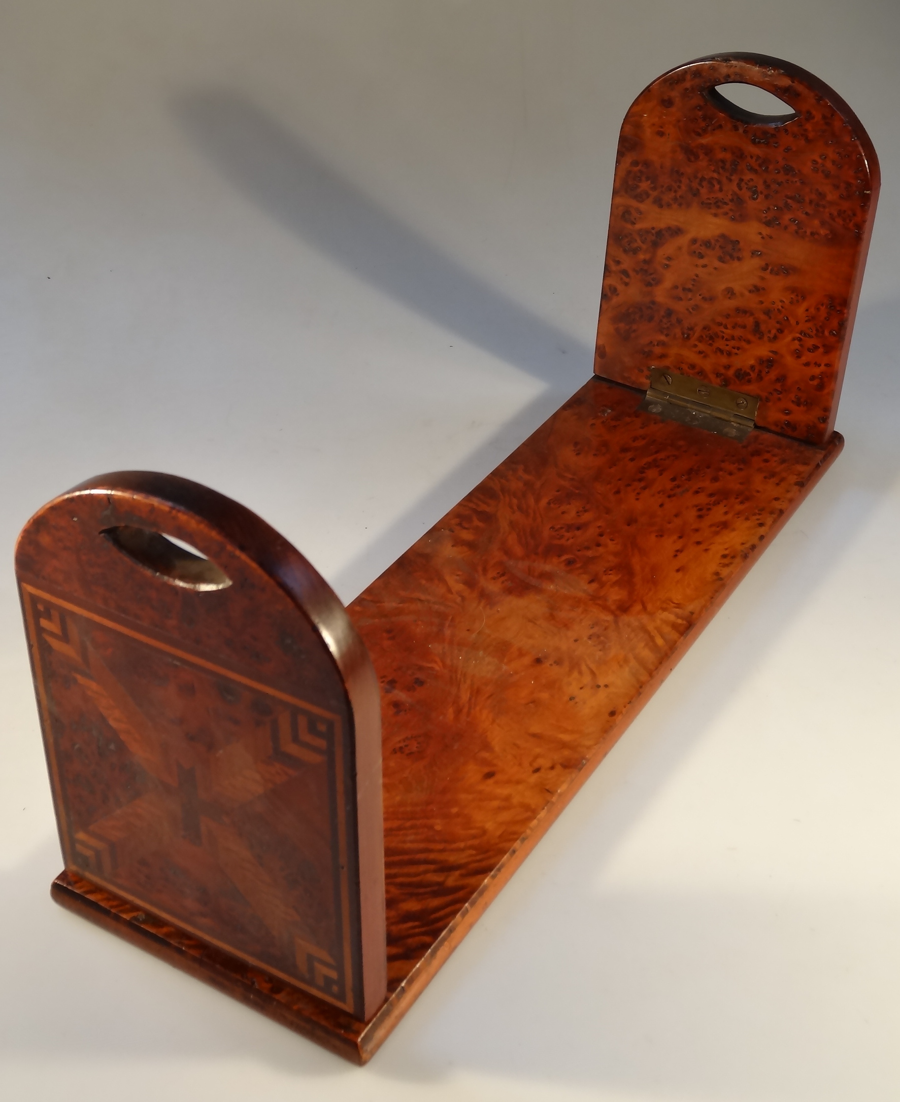 A late 19thC inlaid burr walnut book stand, the rounded end supports with parquetry panel and