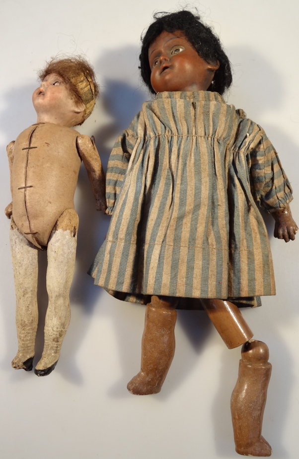 A German bisque headed baby doll, with pot and wooden limbs, 24cm long, another similar, 20cm