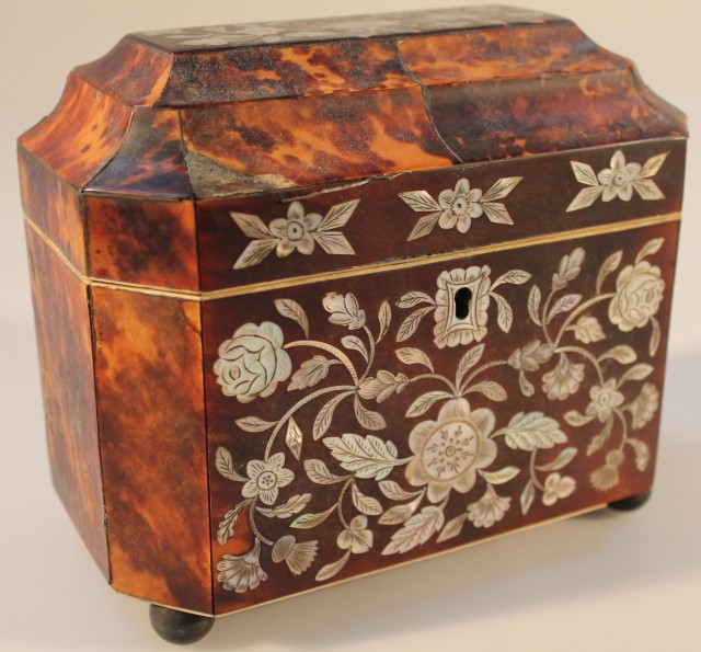 An early 19thC tortoiseshell and mother of pearl inlaid tea caddy, the front and lid inlaid with