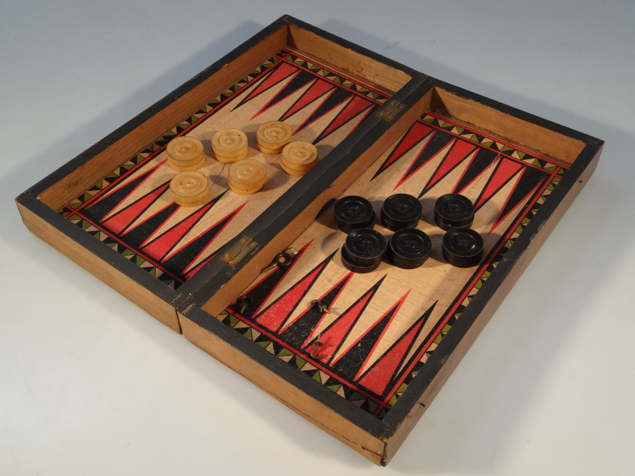 An early 20thC travelling draughts and backgammon set, 38cm long.