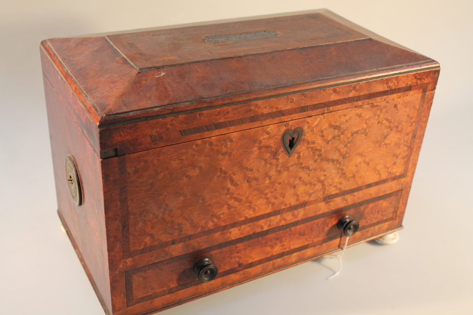 A large 19thC birds eye maple tea caddy, with crossbanding, the sarcophagus shaped cover inlaid with
