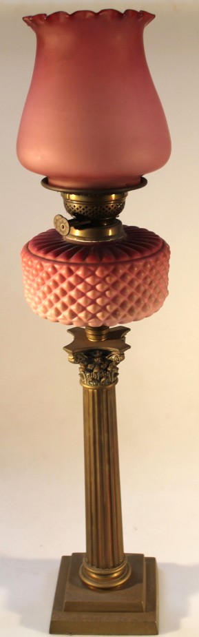 A 19thC oil lamp, with opaque cranberry reservoir on columnar base with square plinth, 73cm high.
