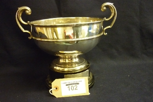 Silver bowl with 2 handles which stands on a wooden plinth, 1970, 20ozs