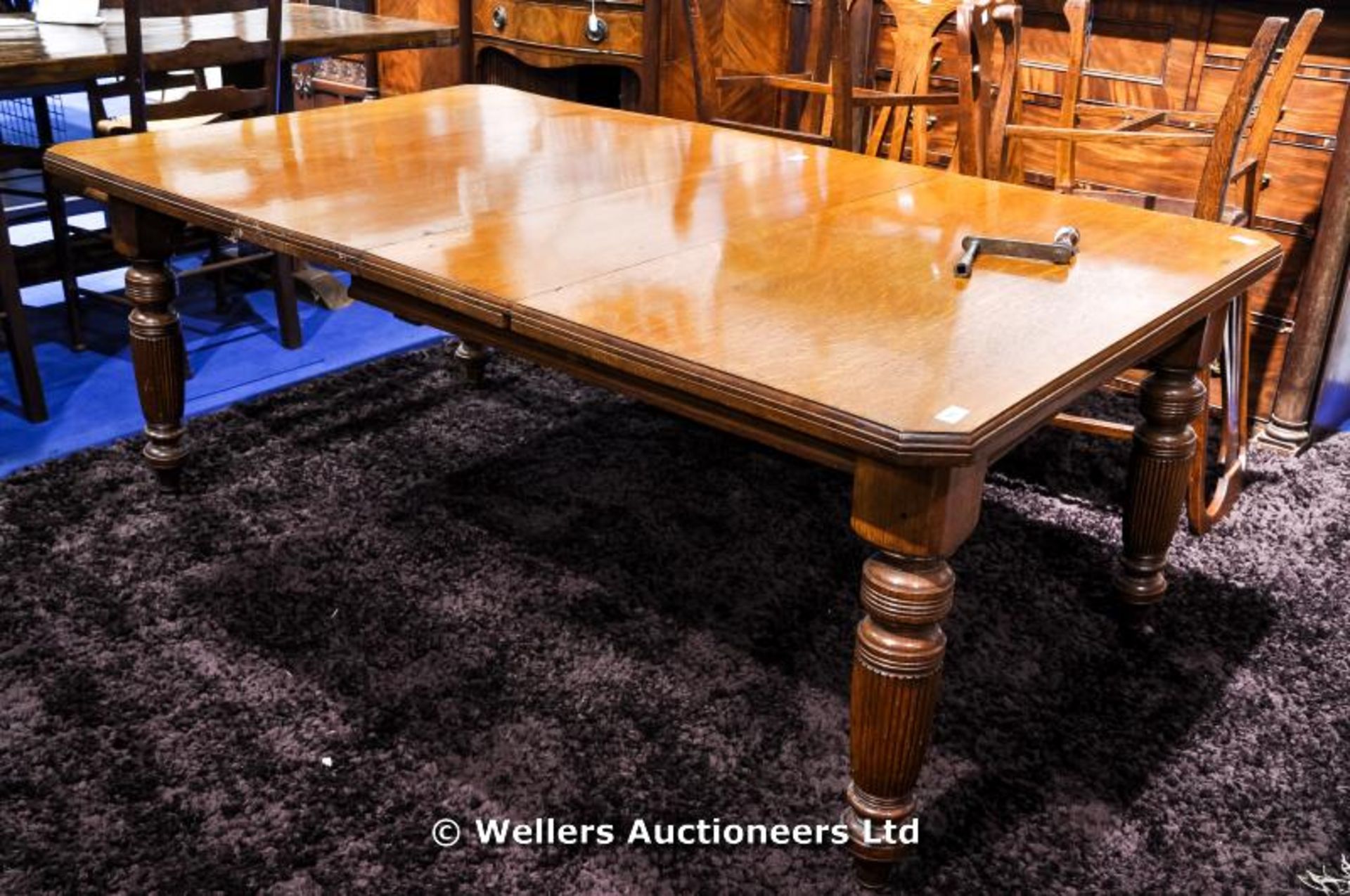 A Victorian wind out oak dining table with reeded column legs, two extra leaves and winder, 179 x