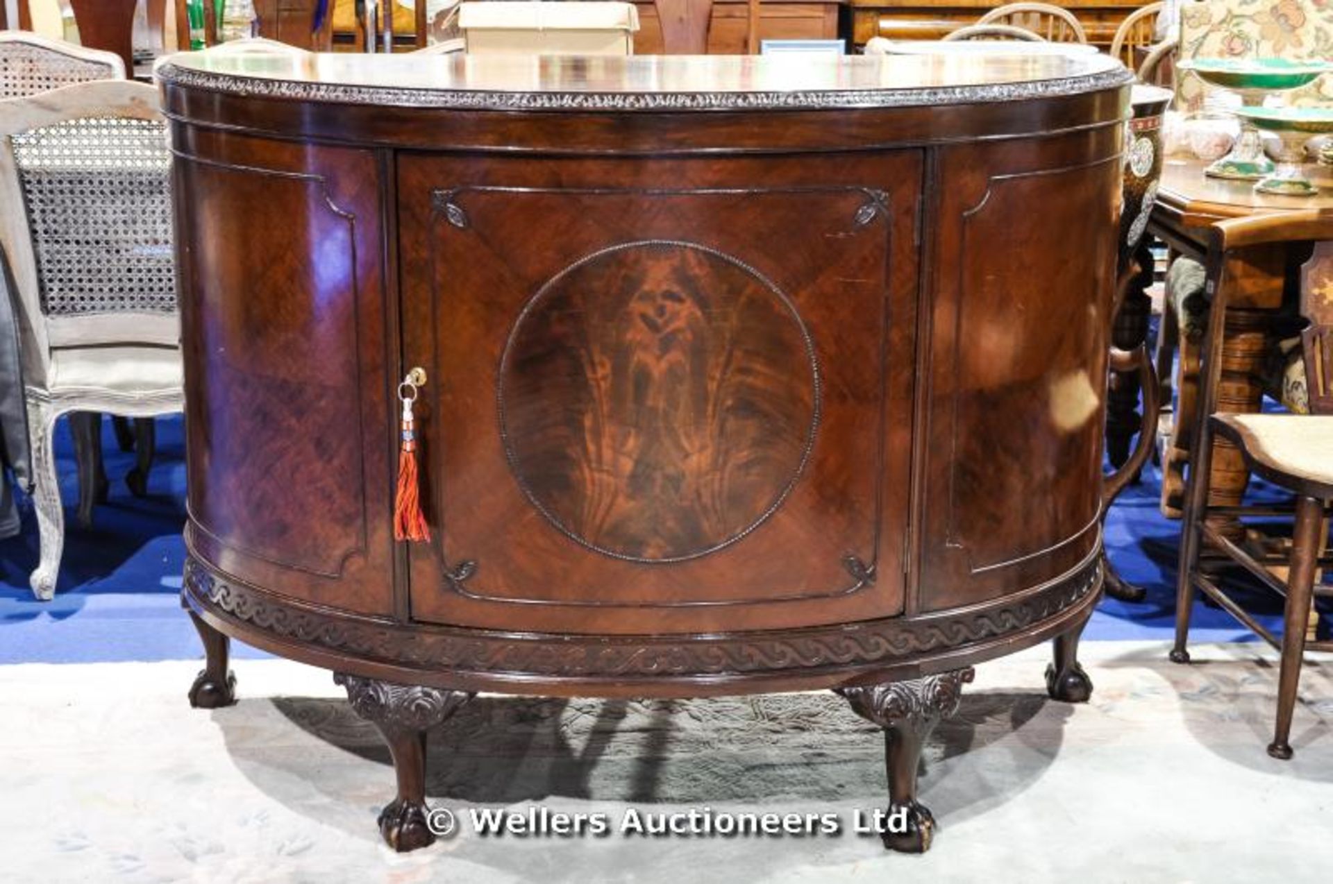 Queen Anne style semi circular sideboard with central cupboard enclosing two shelves, ball and