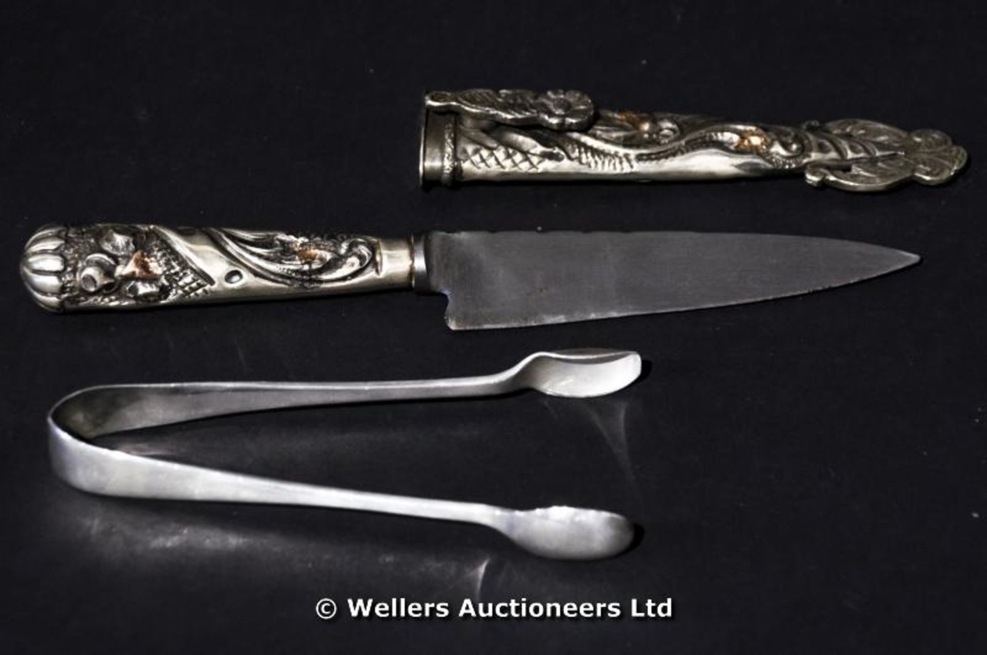 A white metal knife and sheaf made in Argentina together with a pair of silver sugar nips