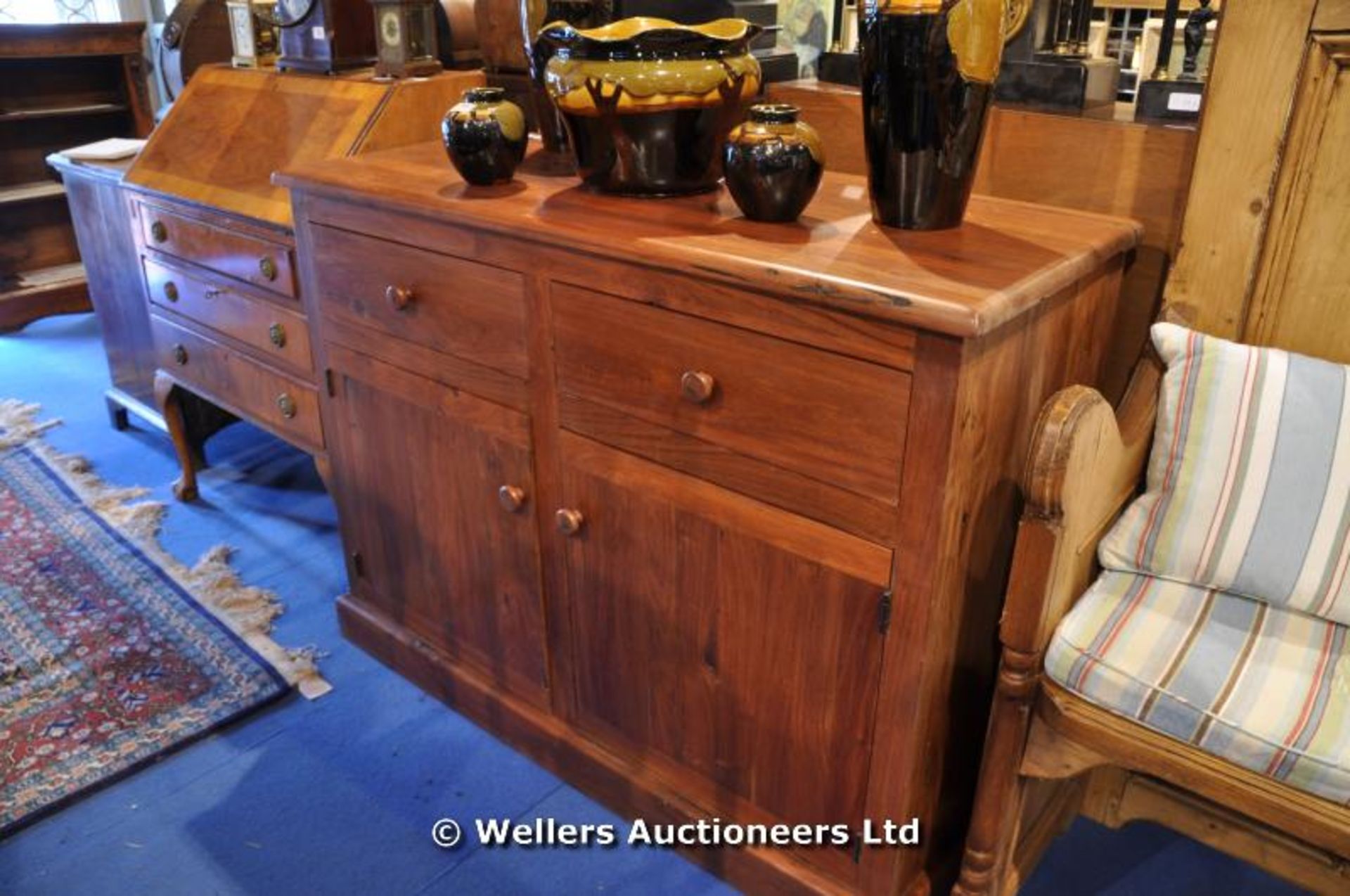 An African Teak sideboard, two drawers over a twin door cupboard