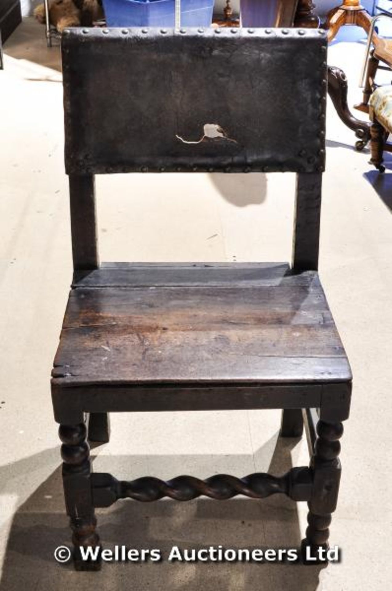 A 17th oak chair with half leather back with stud detailing. Vendors family folklore suggests this