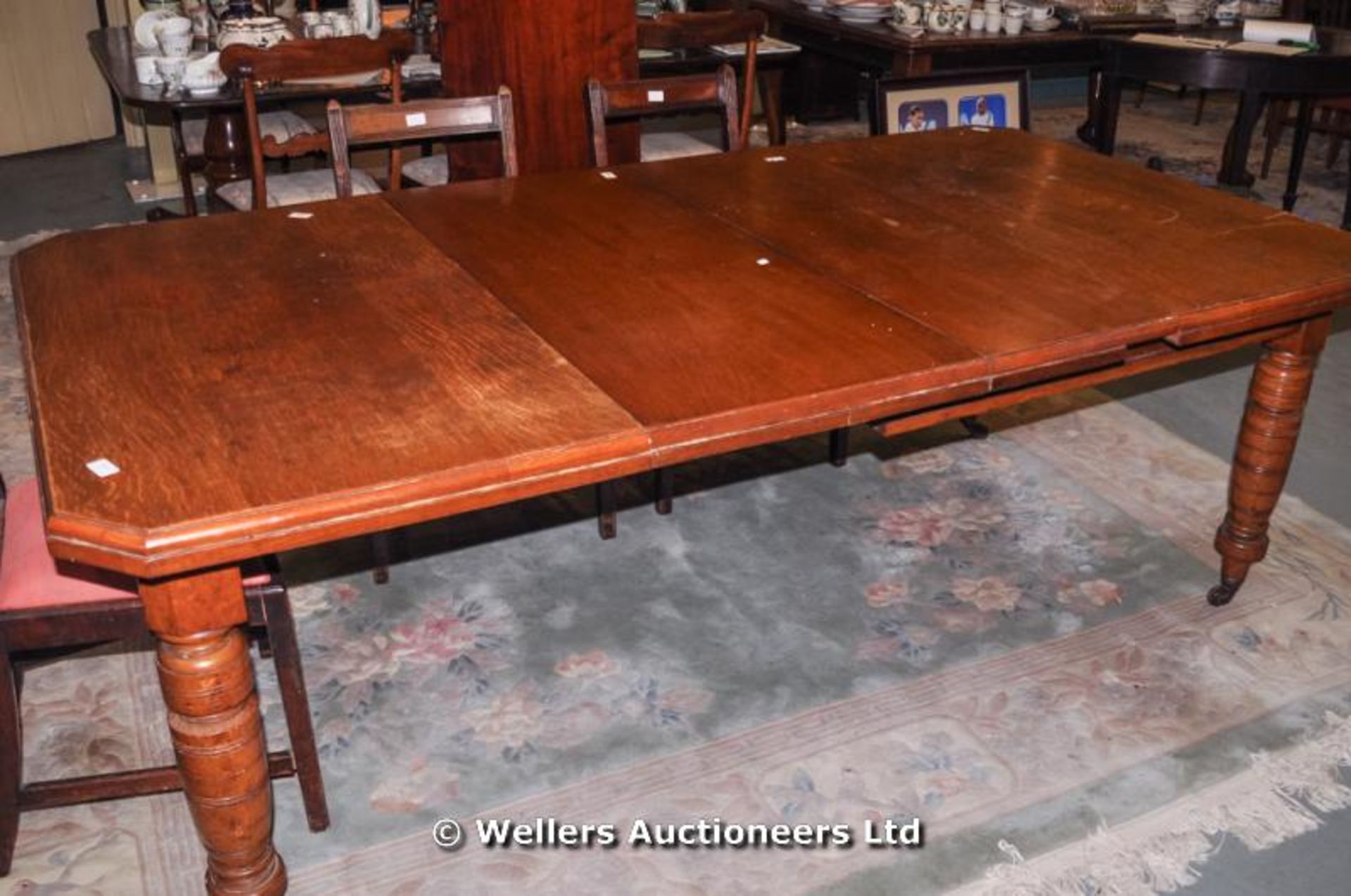 An oak Victorian wind-out dining table with two extra leaves, canted corners - Image 3 of 5
