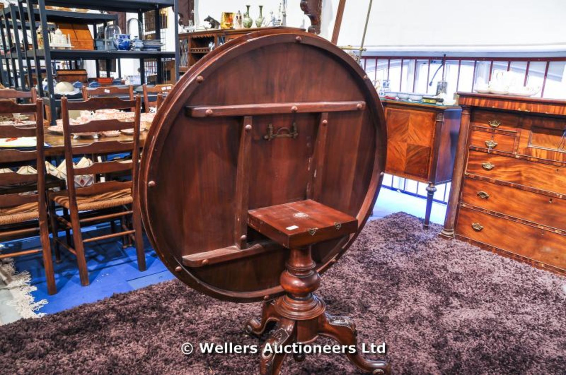 A mahogany tilt top table sitting on turned pedestal with carved tripod legs and original castors, - Image 7 of 8