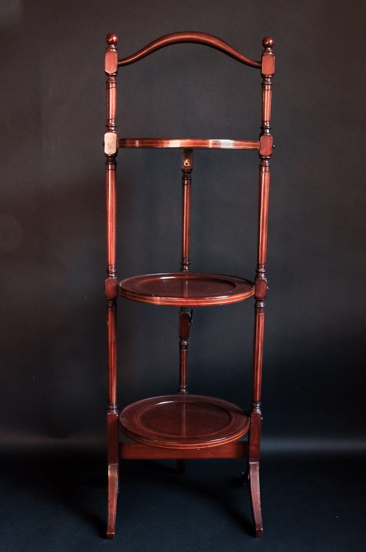 A mahogany three tier cake stand with boxwood stringing, 90cm high