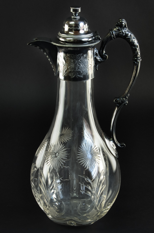 A glass claret jug with silver plated mounts, the body of gourd form, cut in the style of rock