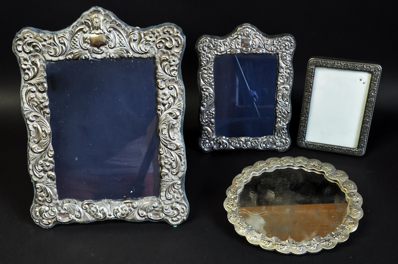 Two silver photograph frames, in ornate Victorian style; a plated frame; and a plated hand mirror,