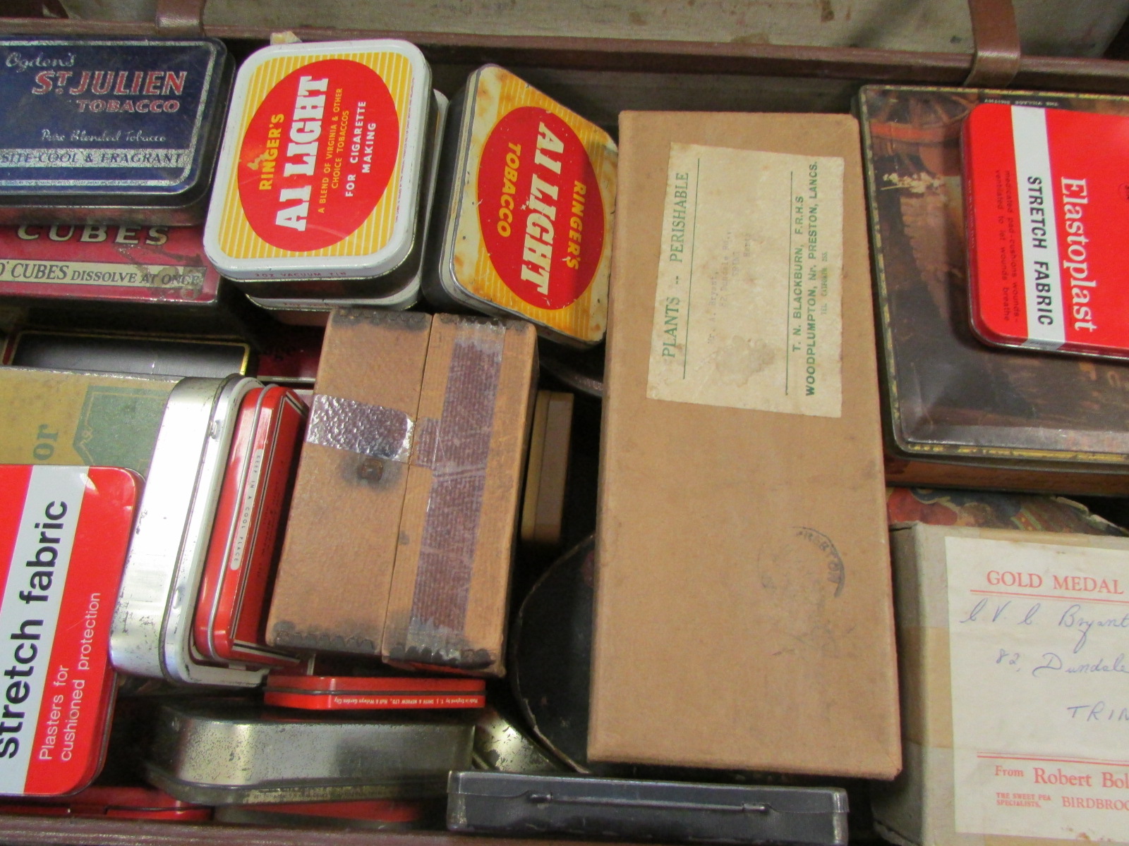 Battered leather suitcase housing old time mixture of stamps contained in approx 30 vintage tins