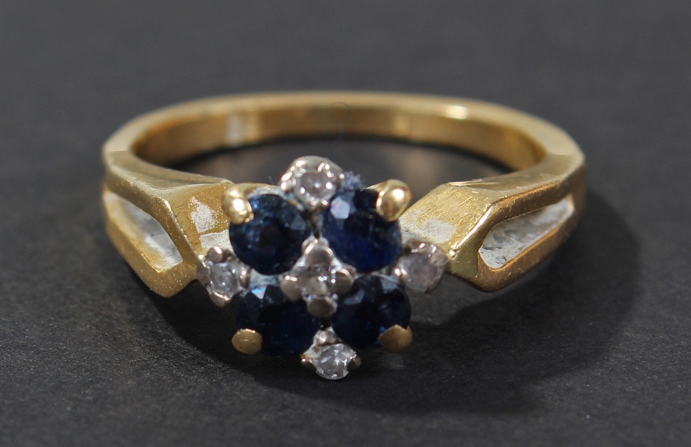 18 carat gold diamond and blue sapphire set ring, of flower head form, set with five diamonds and