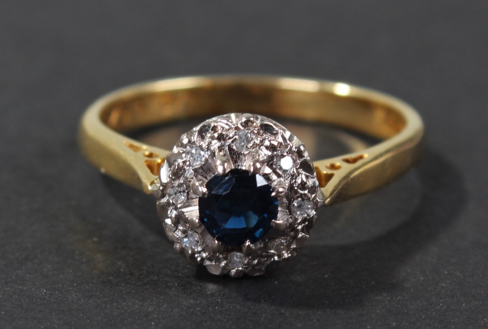 18 carat gold diamond and blue sapphire set ring, of flower head form, centered with single blue