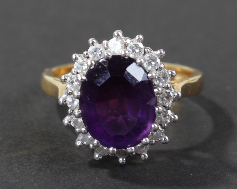 18 carat gold amethyst and diamond set ring, centered with single oval cut amethyst surrounded by