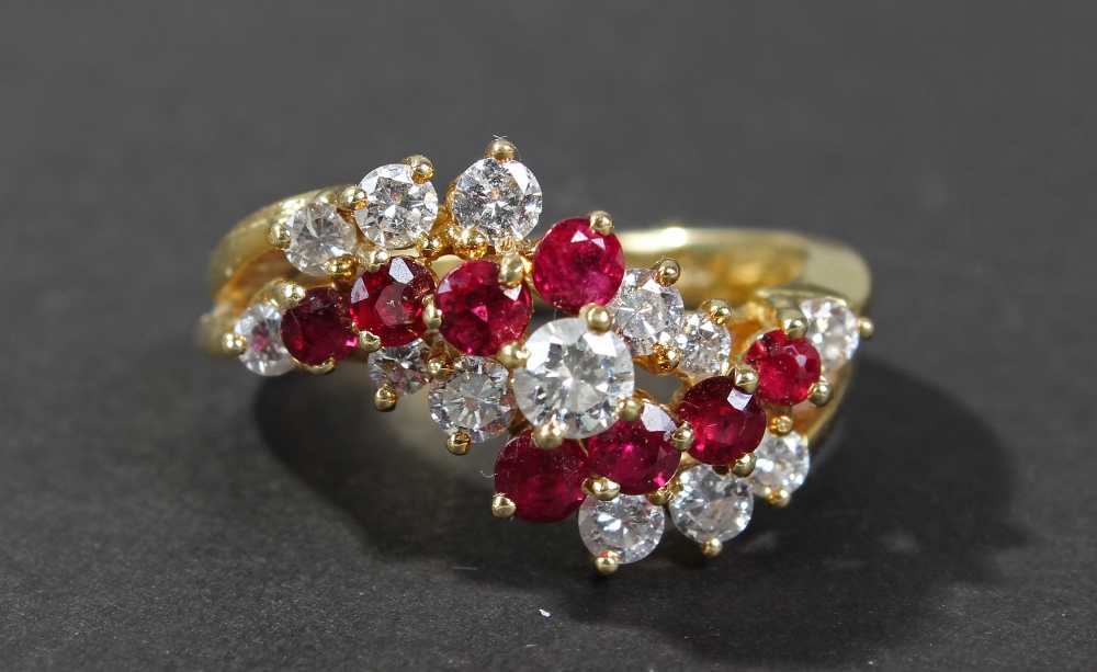 18 carat gold diamond and ruby set crossover ring, the head set with lines of four brilliant cut