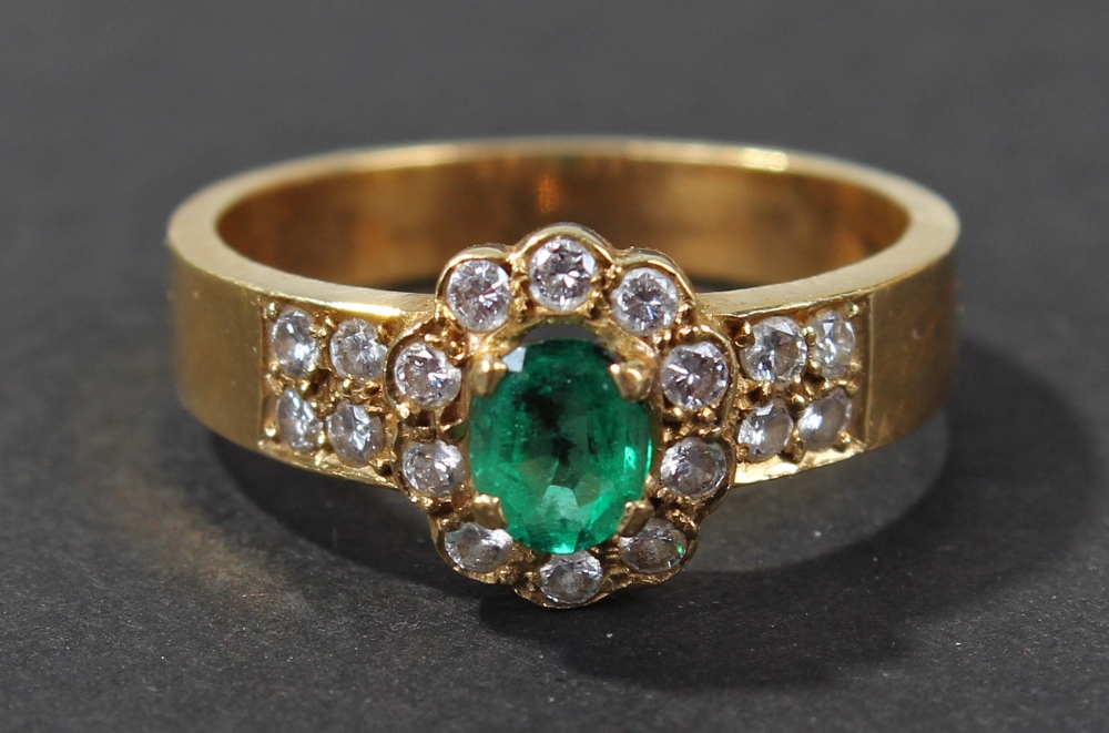 18 carat gold emerald and diamond set ring, of flower head form, centered with single oval cut