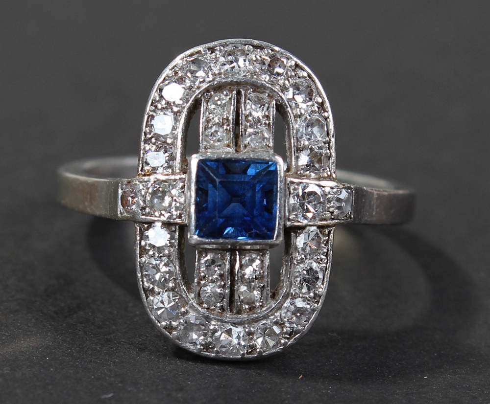 Art Deco white metal diamond and blue sapphire set ring, centered with a single square cut blue