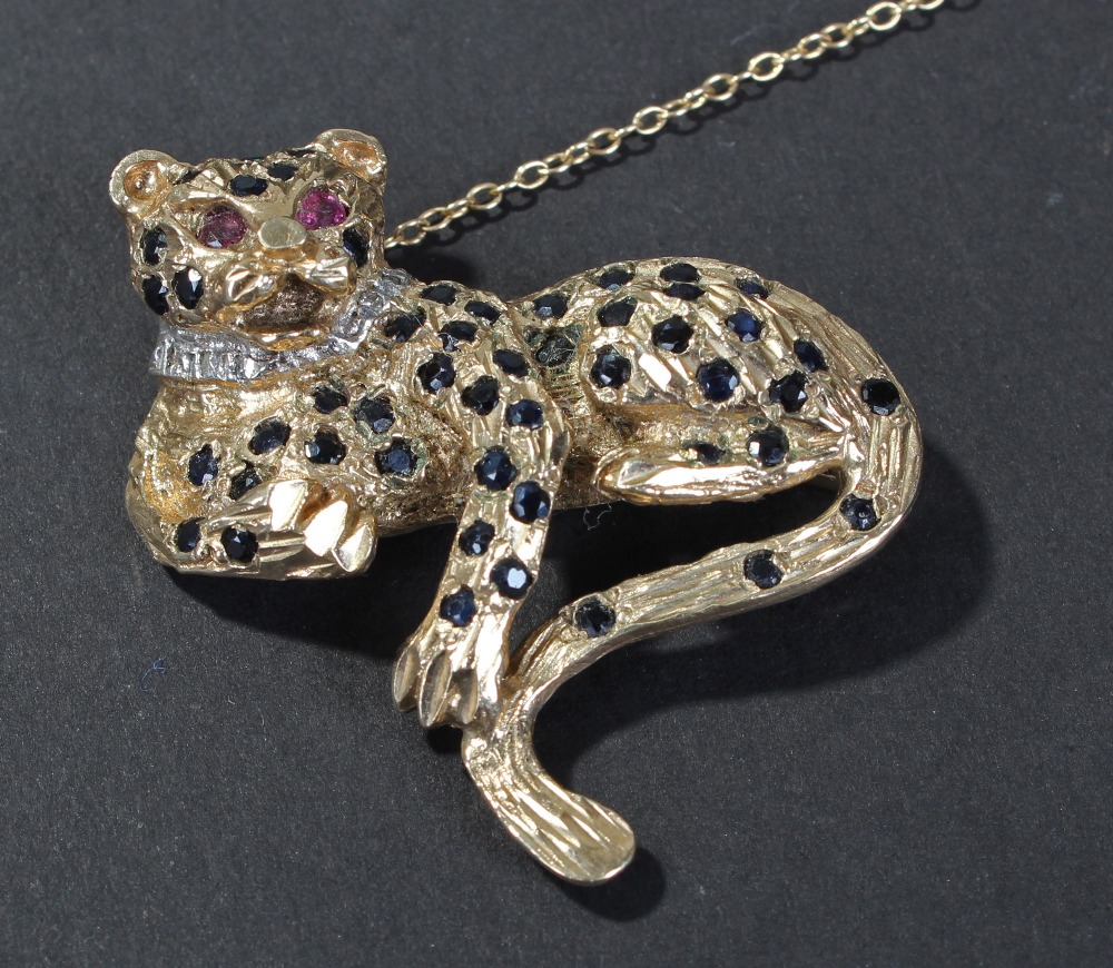 Ladies 9 carat gold leopard brooch, set with sapphires and having ruby set eyes, 3.5cm wide, 10.2
