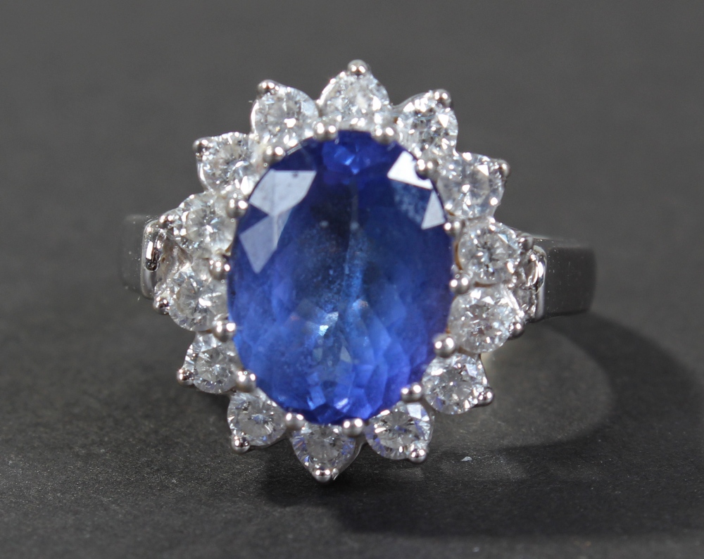 18 carat white gold diamond blue sapphire set ring, of flower head form, centered with oval