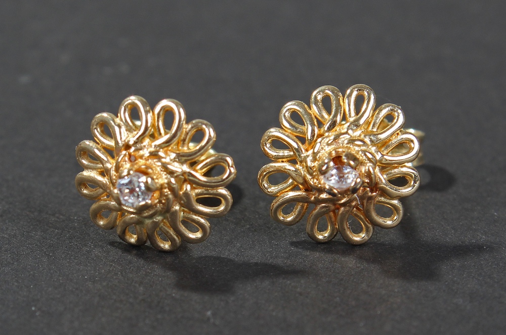 Pair of 14 carat gold earrings, centered with brilliant cut white stones, mounted in 14 carat gold