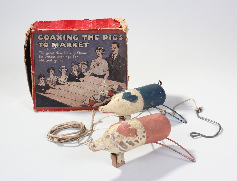 Novelty game `Coaxing The Pigs To Market`, contained in original box and contents of two pigs