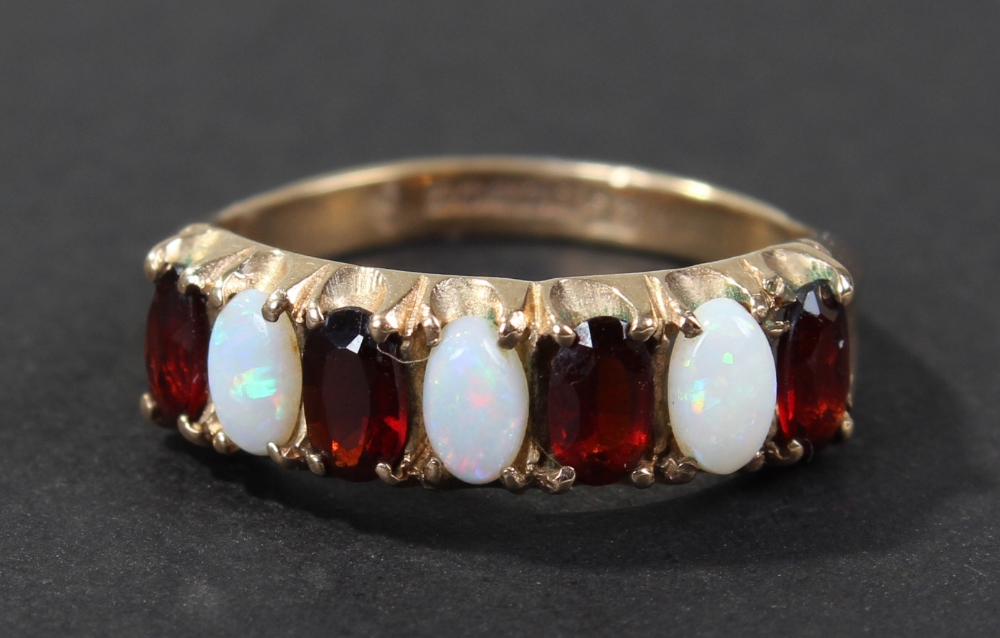 9 carat gold ruby and opal set ring, set with three oval opals and four oval cut rubies, ring size