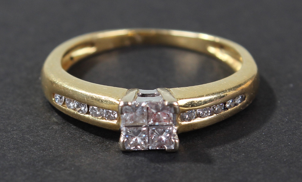 Yellow metal diamond set ring, the head set with four square cut diamonds and with diamond