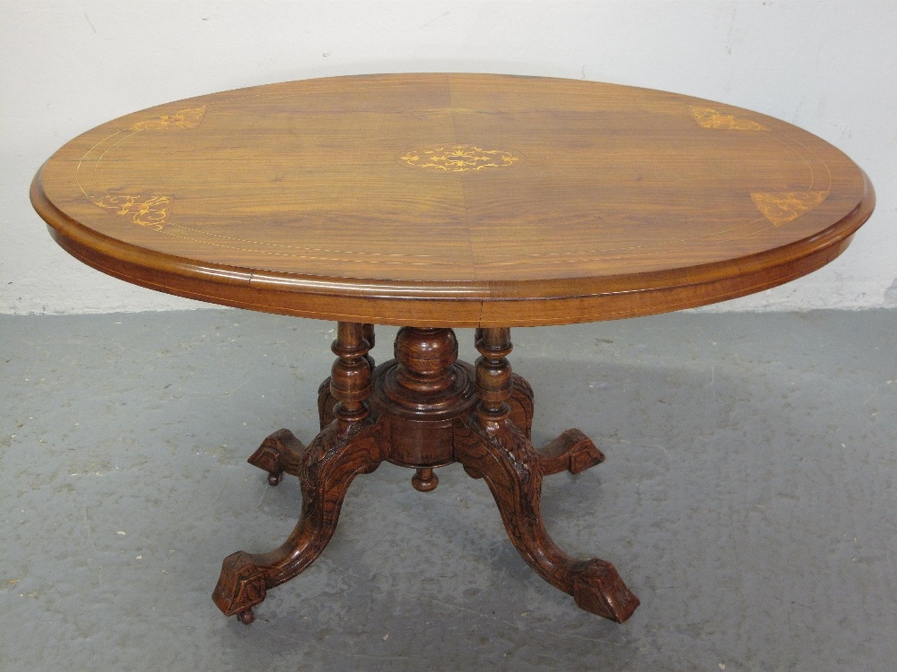 LATE VICTORIAN WALNUT OVAL TIP TOP LOO TABLE having foliate inlaid decoration on a multi column