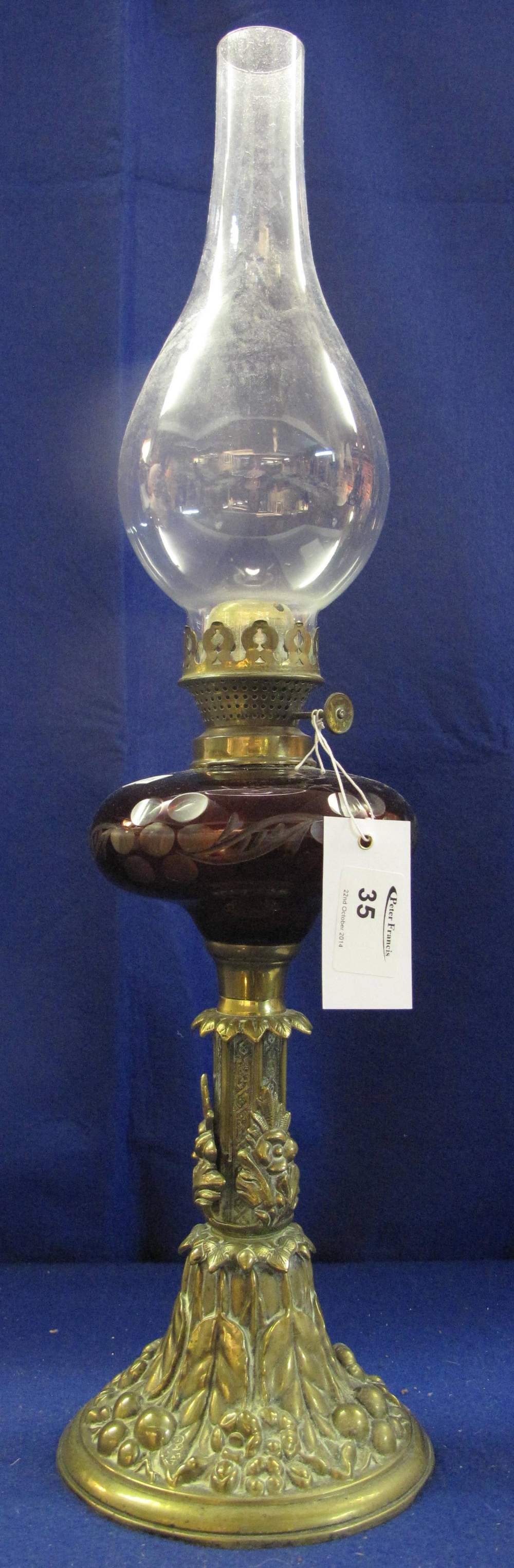 Early 20th Century brass single burner oil lamp with flash cut glass reservoir, relief cast
