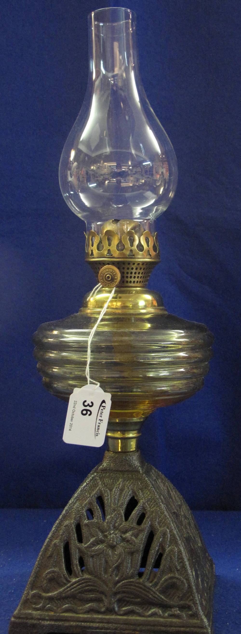 Early 20th Century brass single burner oil lamp with coloured glass reservoir, cast metal base,