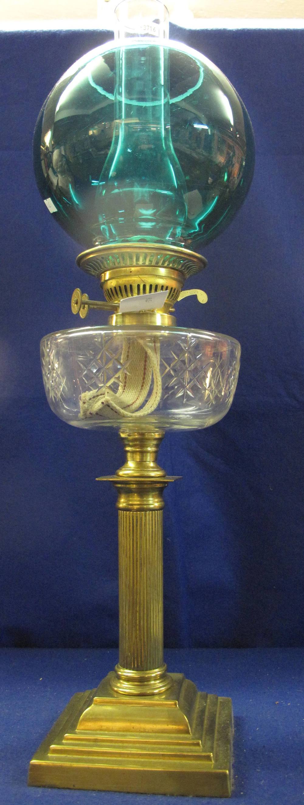 Early 20th Century brass double burner oil lamp with clear cut glass reservoir on reeded brass