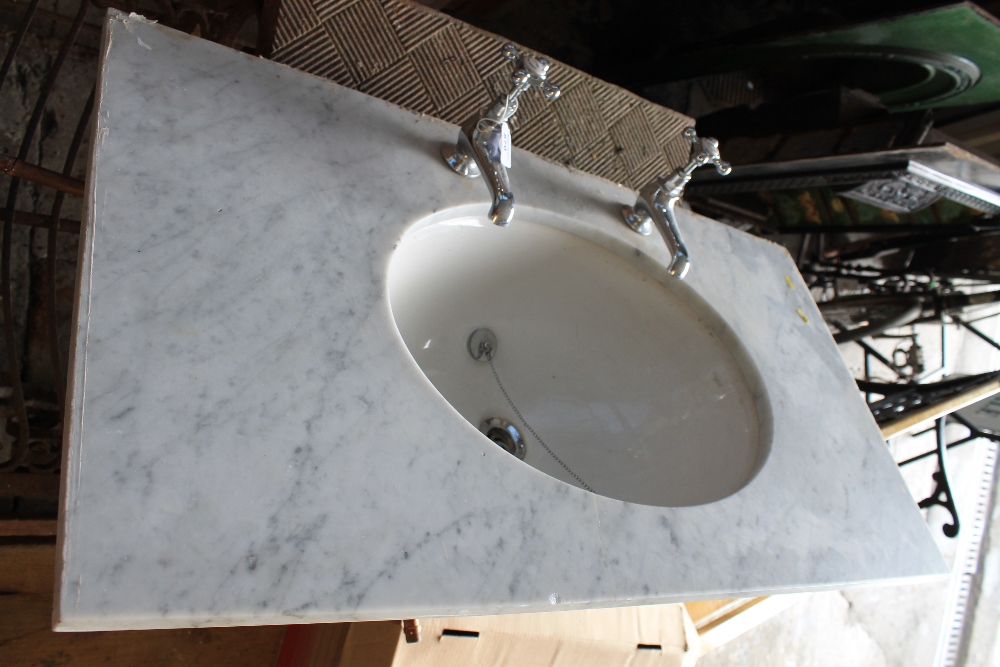 Veined white marble vanity top with oval wash hand basin and fitted Barber Wilson chrome taps.